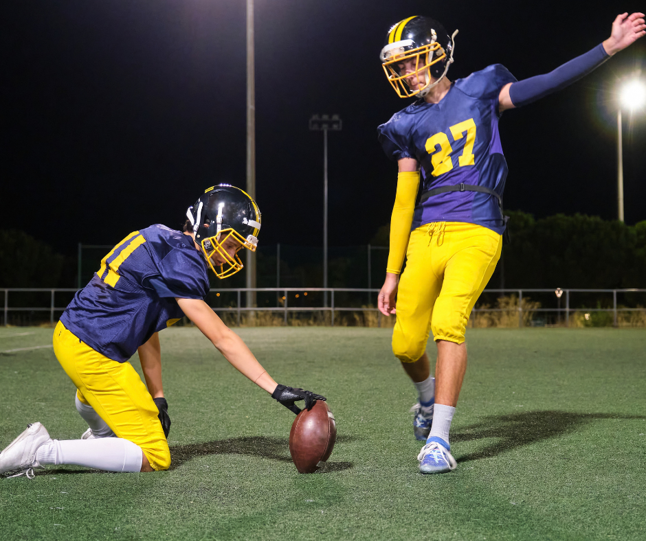 high school football player kicking a ball